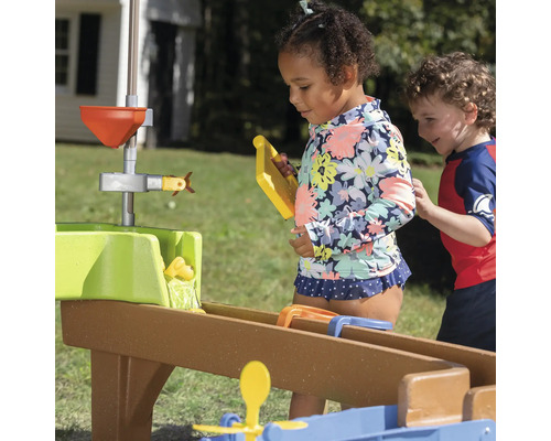 Des enfants jouent avec un système de circuit d''eau à l''extérieur.