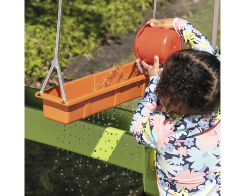 Un enfant joue avec une rigole à eau à l''extérieur