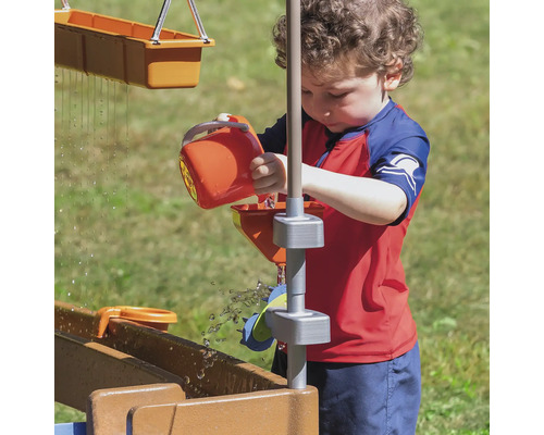 Enfant joue avec un circuit d''eau dans le jardin