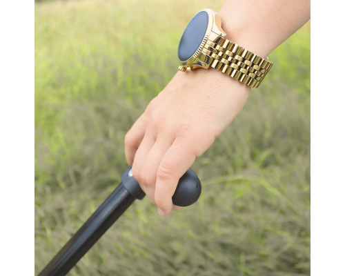Une main tient une canne et porte une montre intelligente avec un bracelet en métal.