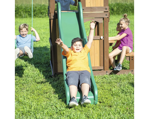 Un enfant glisse sur un toboggan de terrain de jeu pendant que d''autres enfants se balancent et s''assoient sur le banc
