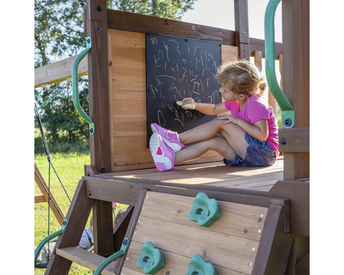 Enfant dessinant à la craie sur un tableau sur une aire de jeux en bois