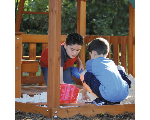 Zwei Kinder spielen im Sandkasten eines Spielturms.