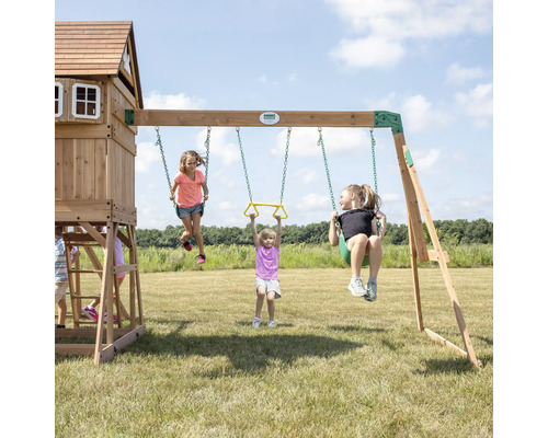 Aire de jeux avec balançoires, tour et enfants sur une pelouse
