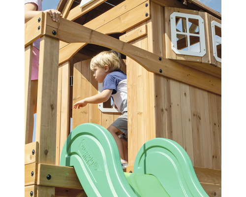 Enfant sur une tour de jeux en bois avec toboggan