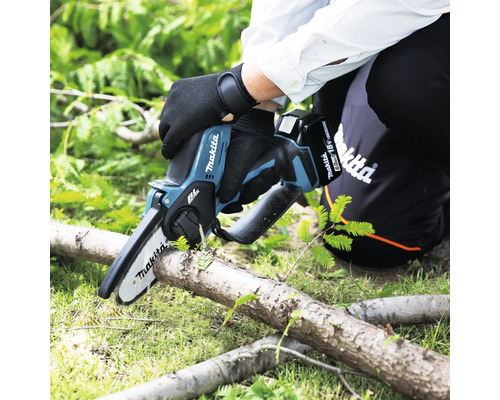 Makita Akku-Astsäge im Einsatz beim Sägen eines Astes.