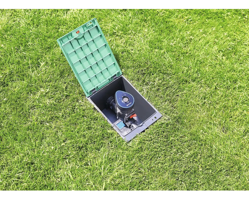 Arroseur escamotable avec boîtier ouvert dans la pelouse