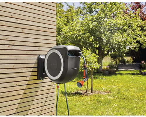 Dévidoir de tuyau d''arrosage avec tuyau et lance pour l''arrosage du jardin, monté sur un mur en bois