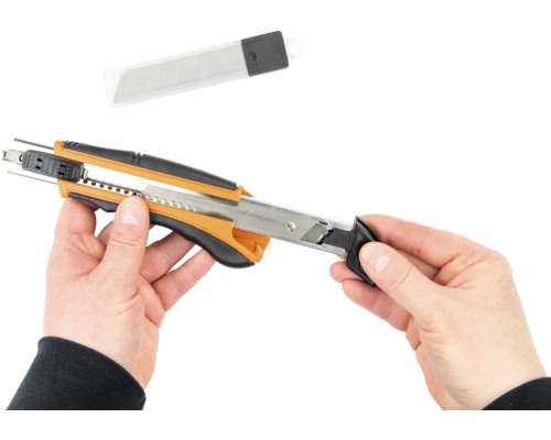 Mains tenant un cutter et des lames de rechange