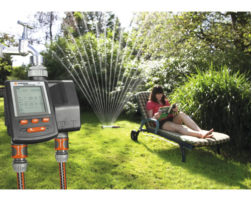Jardin avec robinet d''eau, programmateur d''arrosage Gardena et femme sur une chaise longue
