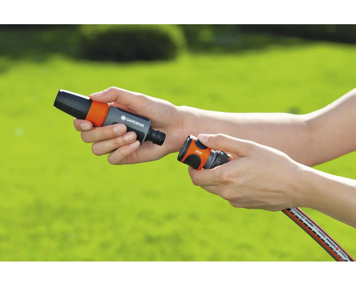 Personne connectant des raccords de tuyau d''arrosage Gardena.