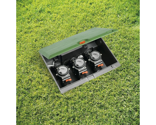 Boîtier de vannes d''arrosage avec trois vannes dans la pelouse