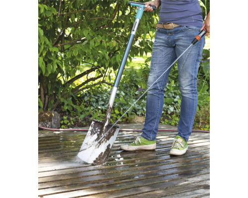 Personne nettoyant une terrasse avec un nettoyeur de terrasse Gardena et un tuyau d''arrosage
