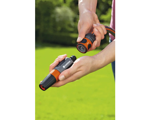 Zwei Hände verbinden ein Gardena Schlauchstück mit einem Wasserstop-Anschluss.