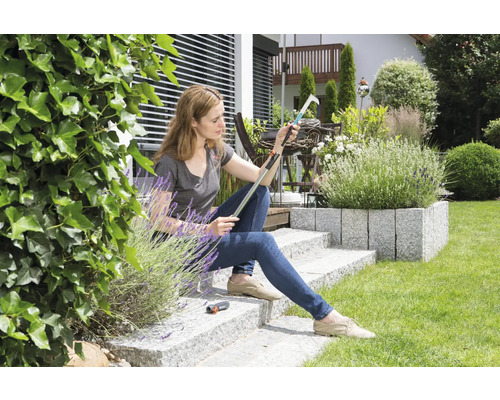 Femme assise dans le jardin inspectant un cueille-fruits