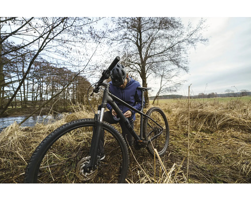 Ein Mann repariert sein Fahrrad in der Natur