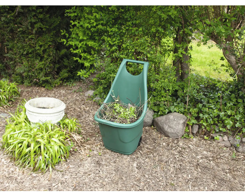 Scène de jardin avec une pelle de jardin remplie de déchets de jardin