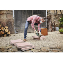 Artisan coupant des pavés avec une meuleuse d'angle à l'extérieur.