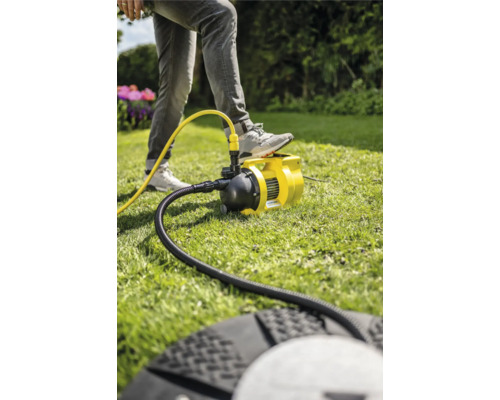 Pompe de jardin en marche avec une personne sur la pelouse