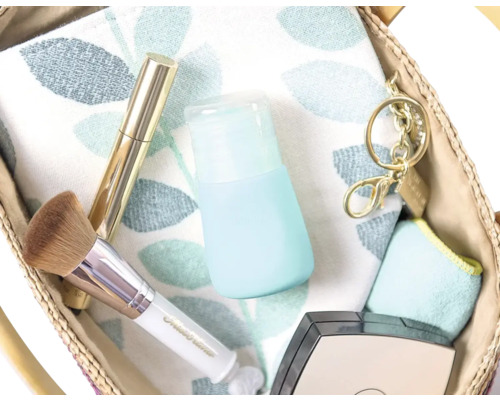 Vue d''un sac contenant un pinceau de maquillage, un mascara, une lotion et un porte-clés