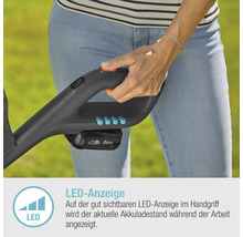 Nahaufnahme einer Person, die einen Rasentrimmer mit LED-Anzeige zur Akkulaufzeit hält