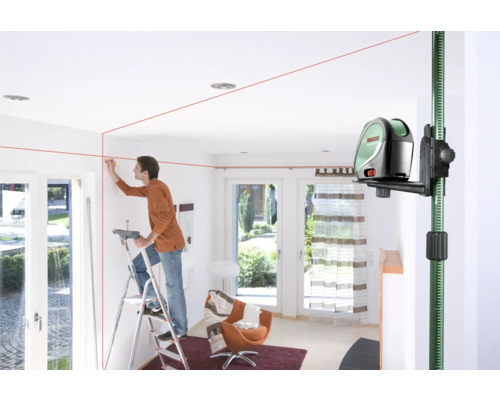 Un homme utilise un laser linéaire à l''intérieur pour l''alignement sur un mur.