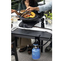 Des personnes font griller des saucisses et des légumes sur un gril de table avec une cartouche de gaz.