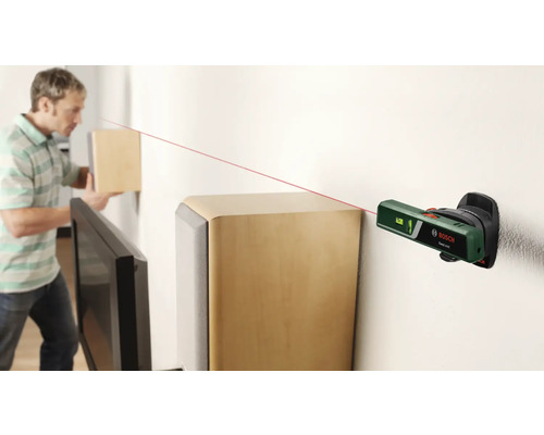 Scène avec un homme alignant un objet sur un mur à l''aide d''un laser linéaire