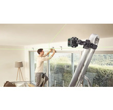 Ein Mann befestigt eine Halterung an der Decke mit Hilfe eines Linienlasers und einer Leiter.