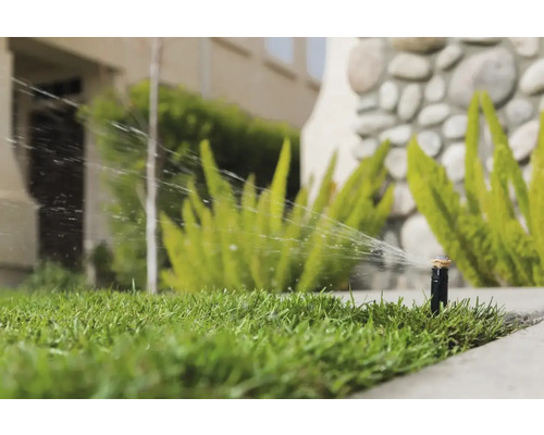 Arroseur de pelouse arrosant une pelouse dans le jardin