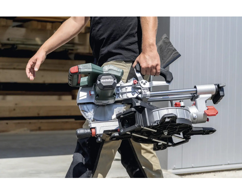 Une personne transporte une scie à onglet Metabo.