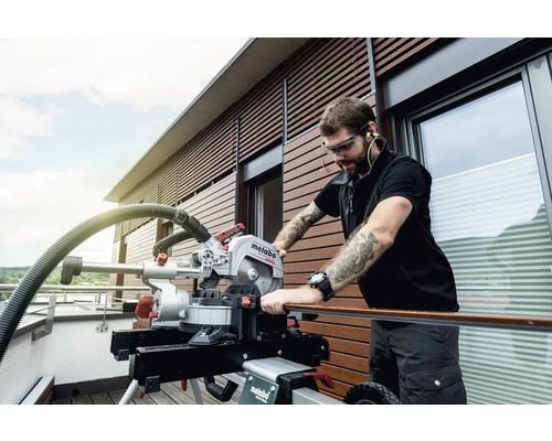 Un homme travaille à l''extérieur avec une scie à onglet Metabo.