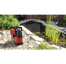Tauchpumpe neben einem Gartenteich mit Steinen und Pflanzen