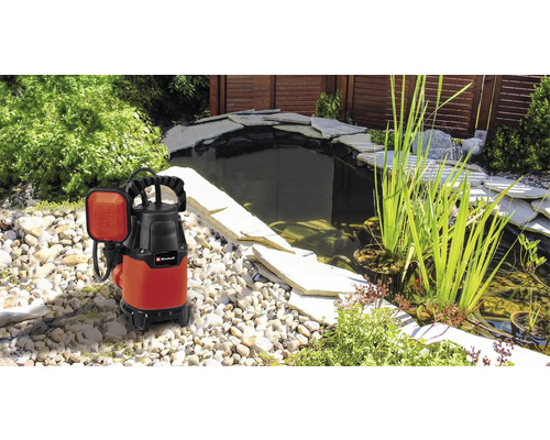 Pompe submersible à côté d''un bassin de jardin avec des pierres et des plantes