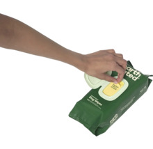 Une main tire une lingette d''un paquet de lingettes pour chiens.