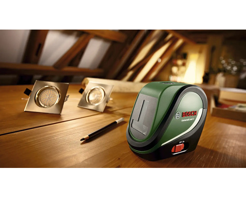 Deux spots encastrables à LED, un crayon et un laser lignes Bosch Universal Level 2 sur une table en bois.
