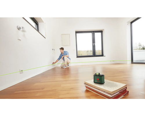 Mann benutzt einen Linienlaser in einem Raum zur Ausrichtung
