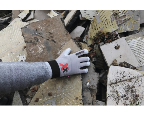 Kinetix Logo auf Arbeitshandschuh vor Bauschutt