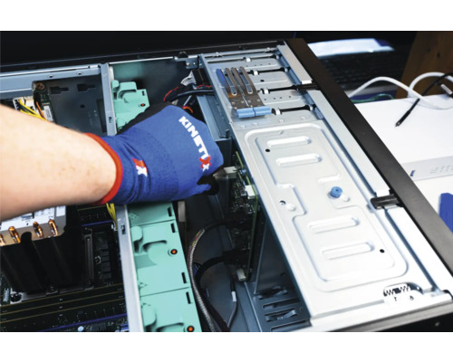 Main gantée installant une carte dans un boîtier d''ordinateur