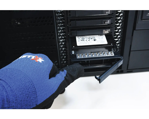 Une personne gantée installe un SSD dans un boîtier d''ordinateur.