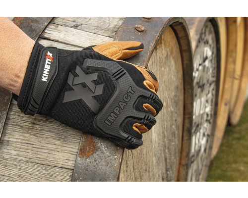 Gant de travail KinetiXx Impact devant des tonneaux en bois