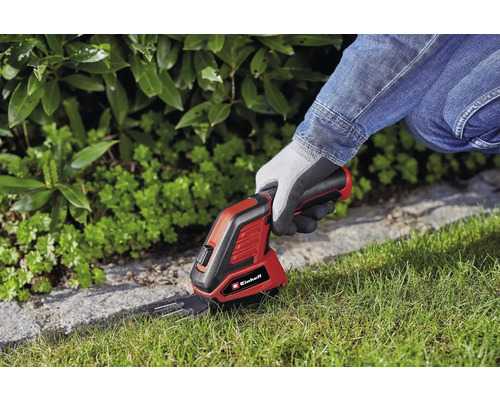 Logo Einhell. Une personne utilise un ciseau à gazon sans fil pour tailler les bordures de pelouse.