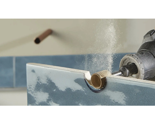 Un carreau est travaillé avec un outil rotatif.