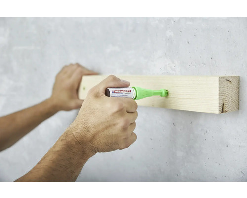 Anwendung des Edding 8870 Klebesiegelstiftes zum Befestigen eines Holzstücks an einer Wand.