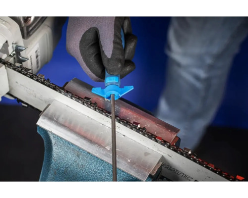 Une personne affûte une tronçonneuse avec une lime