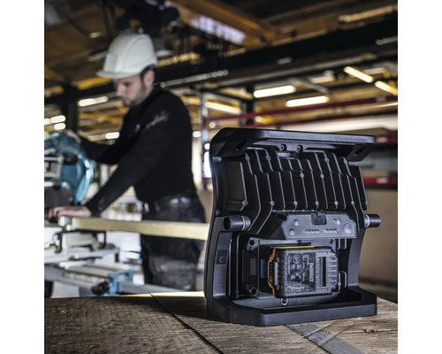 Lampe de travail sans fil utilisée sur un chantier avec un ouvrier