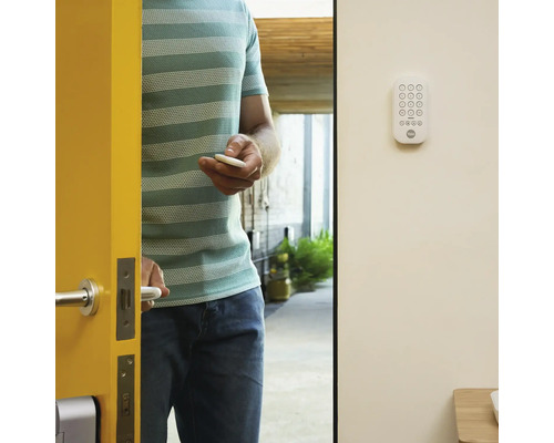 Un homme ouvre une porte avec une serrure de porte électronique et un porte-clés