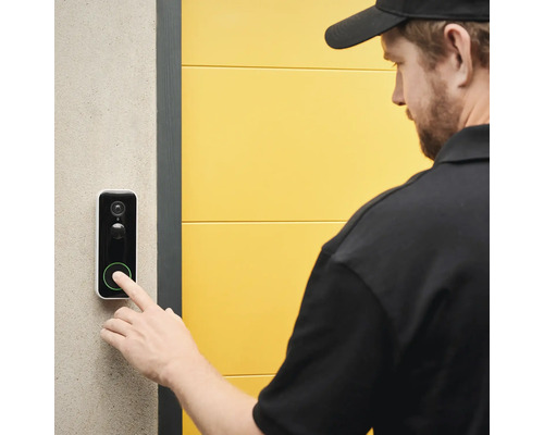 Une personne appuie sur une sonnette avec fonction caméra.