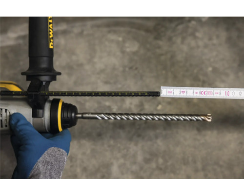 Mesure de la profondeur de perçage avec un mètre pliant sur une perceuse avec foret