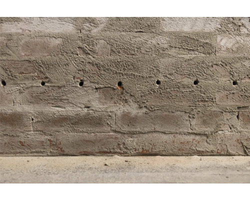 Un mur de briques avec des trous de forage.